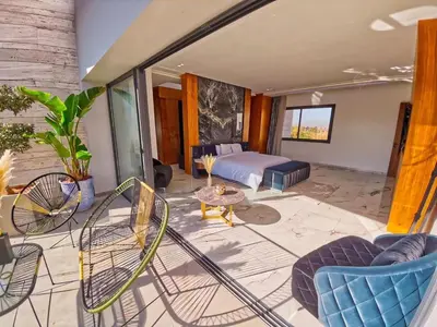 a bedroom with a bed and chairs and a table at Villa Beverly hills-luxury home in Marrakech