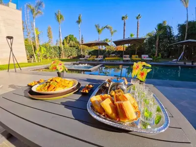 a tray of food on a table next to a pool at Villa Beverly hills-luxury home in Marrakech