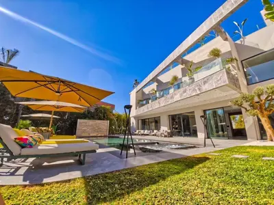 a patio with an umbrella and chairs and a pool at Villa Beverly hills-luxury home in Marrakech