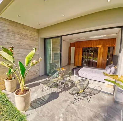 a bedroom with a bed and chairs on a patio at Villa Beverly hills-luxury home in Marrakech