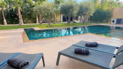 a pool with two chairs and a table next to it at bianca in Marrakech