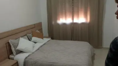 a bedroom with a bed with white sheets and pillows at Bel appartement moderne in Marrakech