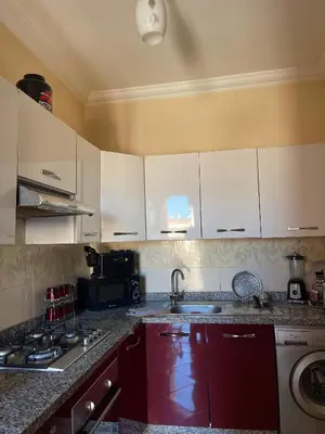 a kitchen with white cabinets and a sink at Bel appartement moderne in Marrakech
