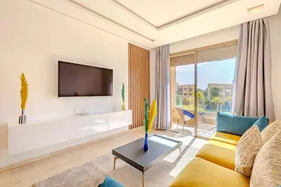 a living room with a couch and a tv at New! Appt Moderne Jubaea avec parking & wifi in Marrakech