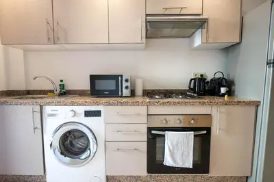a kitchen with a washing machine and a microwave at Hivernage by Louhou Collection in Marrakech