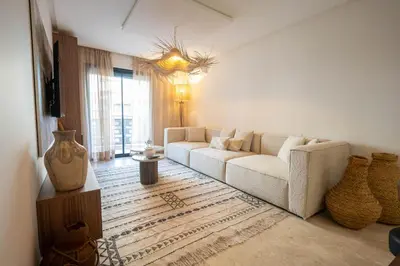 a living room with a white couch and a large window at Hivernage by Louhou Collection in Marrakech