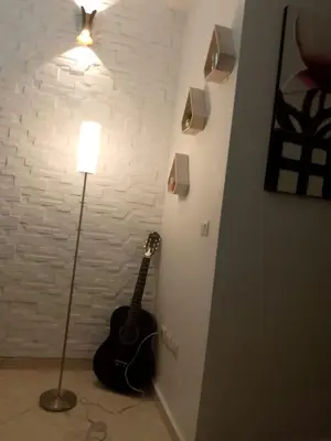 a guitar leaning against a wall next to a lamp at Abwab guilize Beautiful modern apartment in Marrakech