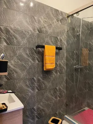 a bathroom with a shower and a yellow towel at Abwab guilize Beautiful modern apartment in Marrakech