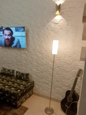 a living room with a couch and a guitar at Abwab guilize Beautiful modern apartment in Marrakech