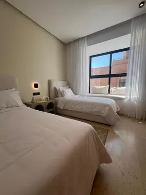 a hotel room with two beds and a window at Dar Zohra in Marrakech