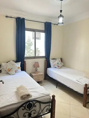 two beds in a room with a window at Charming and Comfortable Room Near Marrakech Airport in Marrakech