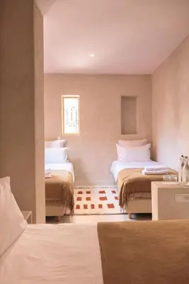 a bedroom with two beds and a window at Riad Manah Marrakech - Ideal for groups & families in Marrakech