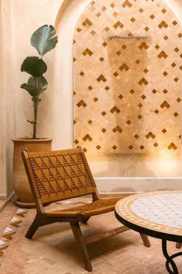a rattan chair and a table in a room at Riad Manah Marrakech - Ideal for groups & families in Marrakech