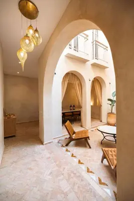 an archway in a living room with a table and chairs at Riad Manah Marrakech - Ideal for groups & families in Marrakech
