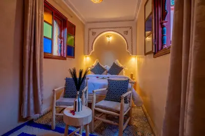 a room with two chairs and a table and windows at Riad Le Graff Pink group in Marrakech