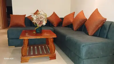 a blue couch with pillows and a table with a vase of flowers at Horizon Sérénité in Marrakech
