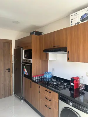 a kitchen with a stove top oven next to a refrigerator at Apparently 2 bedrooms- baby equipment in Marrakech
