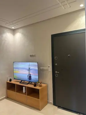 a flat screen tv sitting on top of a wooden cabinet at Apparently 2 bedrooms- baby equipment in Marrakech