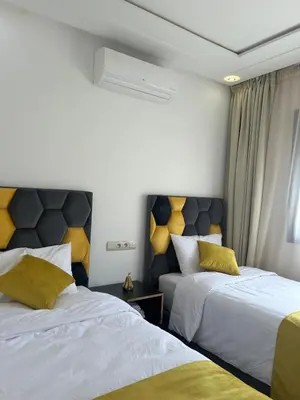 a bedroom with two beds with yellow pillows at Apparently 2 bedrooms- baby equipment in Marrakech