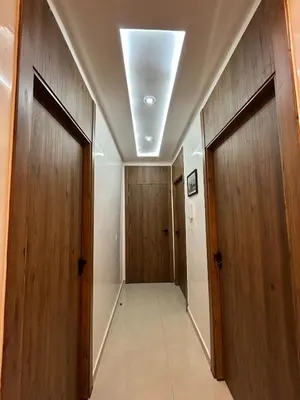 a hallway with two wooden doors and a hallway at Apparently 2 bedrooms- baby equipment in Marrakech