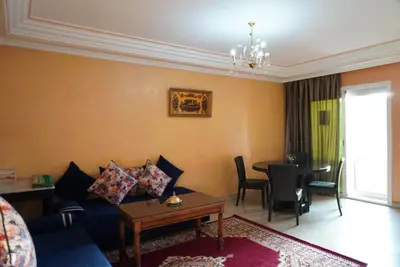 a living room with a blue couch and a table at Maison Nadia in Marrakech