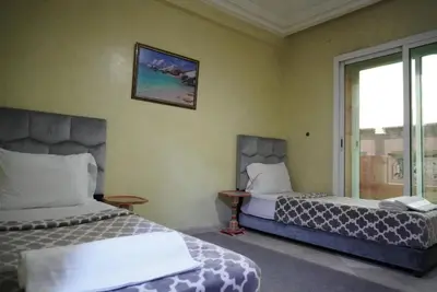 a hotel room with two beds and a window at Maison Nadia in Marrakech