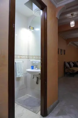 a bathroom with a sink and a shower with a mirror at Maison Nadia in Marrakech