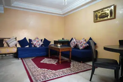 a living room with a blue couch and a table at Maison Nadia in Marrakech