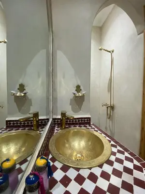 two sinks in a bathroom with a checkered floor at Riad Rose Mati in Marrakech