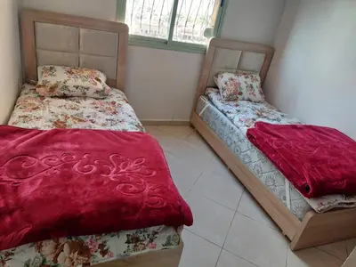 two beds sitting next to each other in a room at Bassatine gueliz 2 in Marrakech