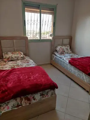 a bedroom with two beds and a window at Bassatine gueliz 2 in Marrakech