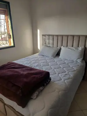 a large white bed in a room with a window at Bassatine gueliz 2 in Marrakech