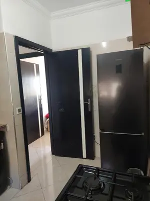 a kitchen with a stove and a black refrigerator at Bassatine gueliz 2 in Marrakech