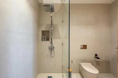 a shower with a glass door next to a toilet at Perfect Villa, Heated Pool, 15min from City Center, 4 Bedrooms, Private Cook and Airport Pickup in Marrakech