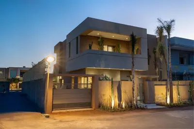 a building with a palm tree in front of it at Perfect Villa, Heated Pool, 15min from City Center, 4 Bedrooms, Private Cook and Airport Pickup in Marrakech