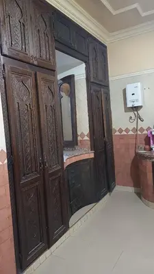 a bathroom with wooden cabinets and a mirror at Marrakech Maroc Guiliz in Marrakech
