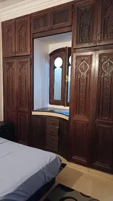 a bedroom with wooden cabinets and a bed and a window at Marrakech Maroc Guiliz in Marrakech