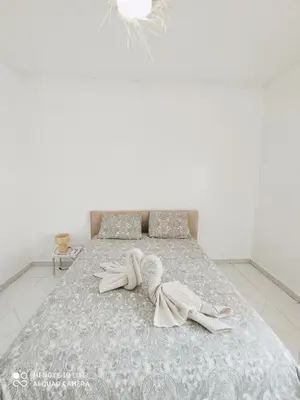 a white bedroom with a bed with two towels on it at Top Location Gueliz Centre in Marrakech