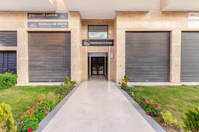 a building with two garage doors and a walkway at Design Calme Luxe Fibre Ultra-Rapide 2CH in Marrakech
