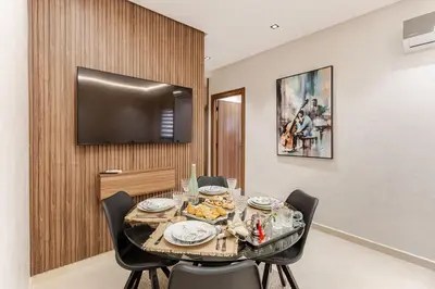 a dining room with a table with chairs and a television at Design Calme Luxe Fibre Ultra-Rapide 2CH in Marrakech