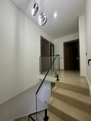 a staircase in a house with a glass railing at Duplex spacieux avec jaccuzi in Marrakech
