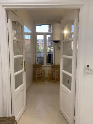 a hallway with white doors and a table and chairs at Gueliz ultra central & Cosy in Marrakech