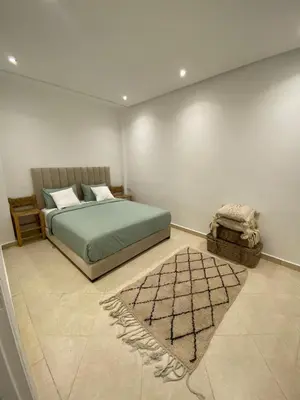 a bedroom with a green bed and a rug at Gueliz ultra central & Cosy in Marrakech