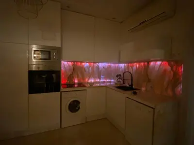 a kitchen with red and pink lights on the wall at Gueliz ultra central & Cosy in Marrakech