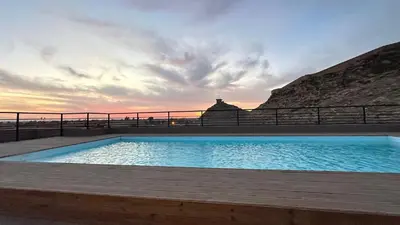 a swimming pool on a deck with a sunset in the background at NEW LUXURY APARTMENT - ViCTOR HUGO MARRAKECH in Marrakech