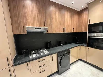 a kitchen with wooden cabinets and a stove top oven at NEW LUXURY APARTMENT - ViCTOR HUGO MARRAKECH in Marrakech