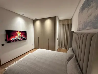 a bedroom with a bed with a painting on the wall at NEW LUXURY APARTMENT - ViCTOR HUGO MARRAKECH in Marrakech