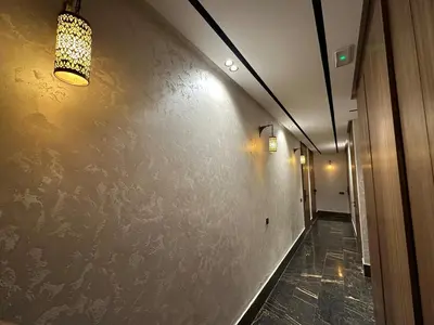 a hallway with a wall with a light on it at NEW LUXURY APARTMENT - ViCTOR HUGO MARRAKECH in Marrakech