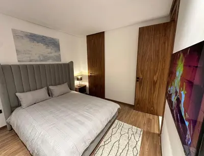 a bedroom with a bed and a painting on the wall at NEW LUXURY APARTMENT - ViCTOR HUGO MARRAKECH in Marrakech