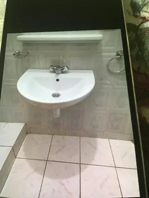a white sink in a bathroom with a tile floor at Riad shamekh in Marrakech